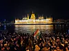 Tusenvis feiret langs Duna-elven i Budapest søndag kveld. På motsatt side lyser parlamentet opp.