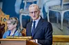 Jonas Gahr Støre står ved talerstolen i Stortinget med mikrofon og dokumenter foran seg.