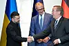Volodymyr Zelenskyj håndhilser på Boris Pistorius med Friedrich Merz stående mellom dem under en seremoni.