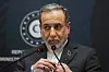 Abbas Araghchi står ved en talerstol foran en mørk blå bakgrunn under en pressekonferanse.