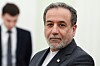 Iransk utenriksminister i dress står innendørs i Kreml med uskarp person i bakgrunnen.