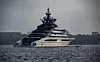 Den store superyachten «Nord» ligger i grått vær ute på vannet nær land.