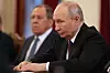 Vladimir Putin sitter ved et møtebord i et formelt rom.