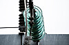 Detaljbilde av høyspentledning med grønne isolatorringer ved en transformatorstasjon.