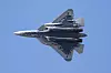 Russisk Su-57-jagerfly i flukt mot blå himmel sett fra undersiden