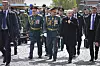 Russiske ledere i uniform og dress går sammen på brosteinen ved Den røde plass i Moskva.