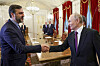 Vladimir Putin og Kazem Gharibabadi håndhilser i en stor møtesal med lang konferansebord.