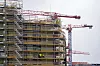 Byggeplass ved Økern i Oslo med boligblokk i stillas og røde kraner
