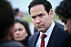 Marco Rubio i dress snakker alvorlig med journalister utendørs.