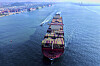 Luftfoto av et MSC-containerfartøy lastet med containere som seiler ut fra en havn.