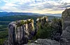 Bratte fjellformasjoner med skog og en enslig turgåer på kanten i solnedgang. Johan Haugsrud (@explorewithjohan) på fjellhyllen Gygrestolen i Bø i Telemark, med utsikt mot Gygrestolen i Telemark, et av Johan Haugsruds anbefalte turmål for sommeren.