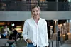Person i hvit skjorte står i et moderne kontor- eller biblioteksbygg. Forbrukerøkonom Lene Drange i moderne kontormiljø illustrerer Norges Banks beslutning om å heve styringsrenten til 4,25 prosent.
