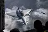 Eurofighter Typhoon-jagerfly flyr i formasjon over skydekket landskap.