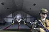 F-35-jagerfly med øvelsesmissiler i hangar, soldat står bevæpnet i forgrunnen.