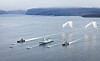 Marinefartøy i formasjon med lysende mottiltak over sjøen i en norsk fjord.
