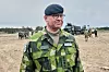 Michael Claesson i svensk uniform står foran soldater og militærkjøretøy under øvelse på Gotland.