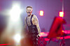 Jonas Lovv synger energisk på scenen med sterke lys og røde scenedetaljer.