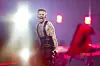 Jonas Lovv synger energisk på scenen med sterke lys og røde scenedetaljer.