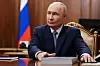 Russlands president ved et skrivebord i Kreml med russisk flagg i bakgrunnen.