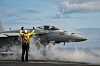 US Navy EA-18G Growler gjør seg klar til takeoff på hangarskip med mannskap på dekk.