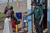 Helsearbeider med munnbind viser besøkende til håndvaskstasjon ved sykehusinngang i Bunia.