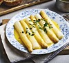 Tallerken med hvit asparges i smørsaus, toppet med friske urter. Tallerken med hvit asparges og smørsaus viser hvor enkel og elegant vårens sesongråvare kan serveres.