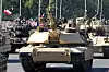 Abrams-stridsvogn i front under militærparade i Warszawa omgitt av flere stridsvogner og publikum.