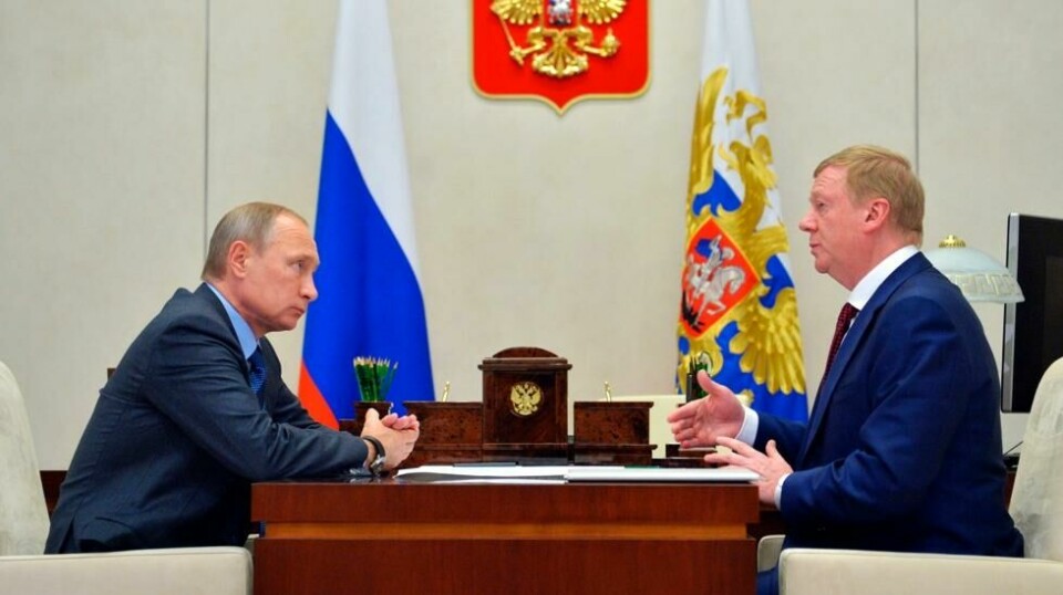 Putin og rådgiveren Anatolij Tjubajs diskuterte energipolitikk i 2016. Nå er Tjubajs innlagt på sykhus etter plutselige lammelser. Foto: AP/NTB