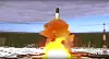 Oppskyting av en stor rakett med lysende flamme og røyk fra en snødekt russisk base.