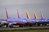 Flere blå Southwest Airlines Boeing 737-fly parkert på bakken ved et industrielt flyanlegg.
