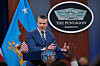 Pete Hegseth taler fra podiet i Pentagon mens reportere rekker opp hendene.