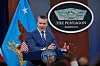 Pete Hegseth taler fra podiet i Pentagon mens reportere rekker opp hendene.