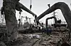 Arbeidere står blant ødelagte rør og ruiner ved Darnytsia-varmekraftverket i Kyiv.