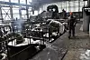 Arbeider med hjelm inspiserer brannskadet turbinhall ved DTEK-kraftverk i Ukraina