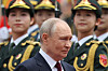 Vladimir Putin går forbi kinesisk æresgarde i paradeuniformer utendørs.