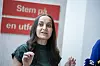 Seher Aydar fra Rødt taler foran et rødt skilt under en pressekonferanse.