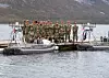 Soldater i uniform på brygge mellom to små militære båter i fjord
