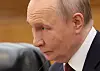 Nærbilde av Vladimir Putin sittende ved et møtebord i dress.