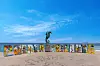 Fargerike PUERTO VALLARTA-bokstaver og sjøhestskulptur ved havpromenade under blå himmel.