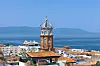 Kirketårn og gamle bygninger i Puerto Vallarta ved havet.