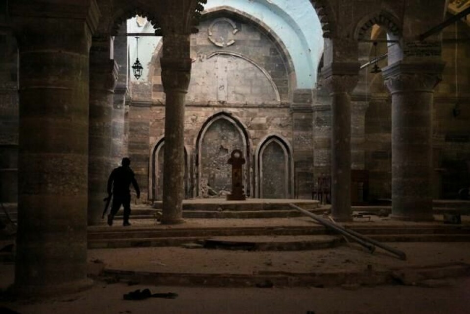Medlem av en kristen militsgruppe i en kirke som ble ødelagt av IS under okkupasjonen av byen Tilkaif, som har kristen flertallsbefolkning. Jihadistene brukte kirken til «bønn og skytetrening», sier naboer til APs fotograf. Bildet er tatt 24. januar. Medlem av en kristen militsgruppe i en kirke som ble ødelagt av IS under okkupasjonen av byen Tilkaif, som har kristen flertallsbefolkning. Jihadistene brukte kirken til «bønn og skytetrening», sier naboer til APs fotograf. Bildet er tatt 24. januar. Foto: Khalid Mohammed / AP