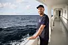 Daniel Bengtsson fra Greenpeace Nordic står ved rekka på et forskningsfartøy i åpent hav.