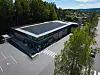 Luftfoto av dagligvarebutikk med solcellepaneler og tom parkeringsplass