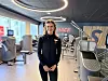 Instruktør står i et SATS-treningssenter omgitt av moderne styrkeapparater.