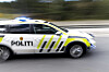 Norsk politibil med blålys i fart på vei.