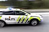 Norsk politibil med blålys i fart på vei.