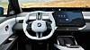 Interiør i BMW iX3 med hvitt ratt og stor digital skjerm i moderne elbilkupé.