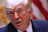 Donald Trump i nærbilde mens han taler, med USAs flagg i bakgrunnen.