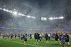 PSG-lag og støtteapparat feirer på banen i en røykfylt Puskas Arena etter finalekamp.