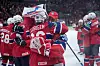 Norske ishockeyspillere i røde drakter feirer sammen på isen etter kamp.